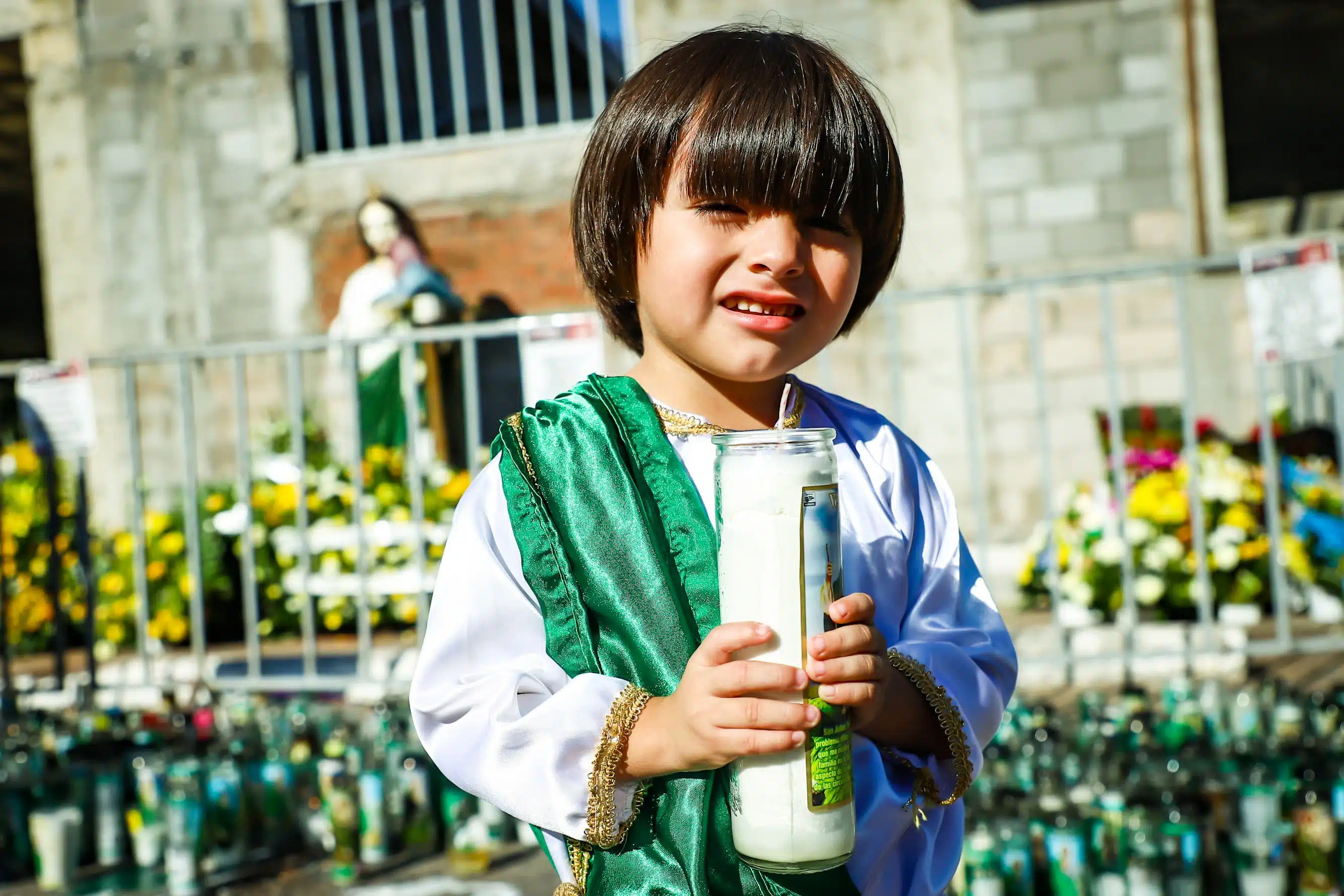 Niño con una vela en las manos, vestido de San Judas Tadeo