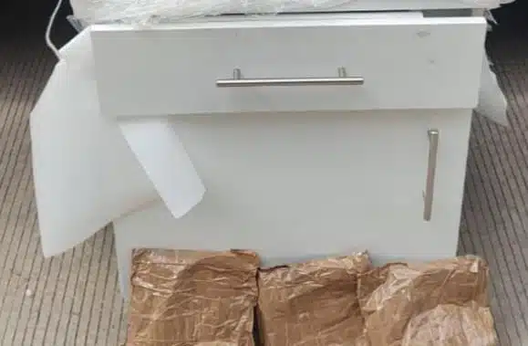 Envoltorios de droga que estaban ocultos en el mueble de madera