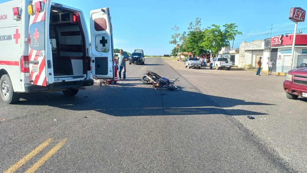 Motocicleta tirada en la carretera junto a ambulancia