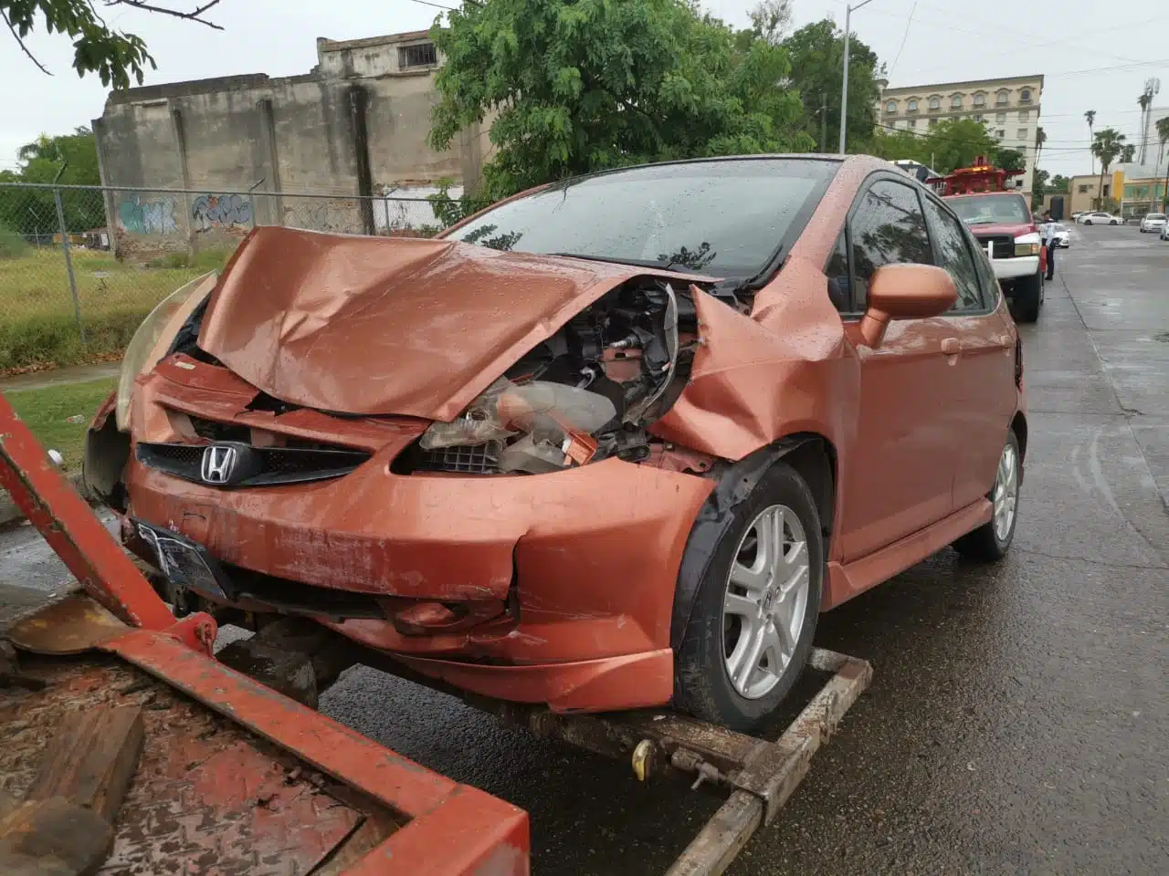 Vehículo Honda Fit levantado por grúa