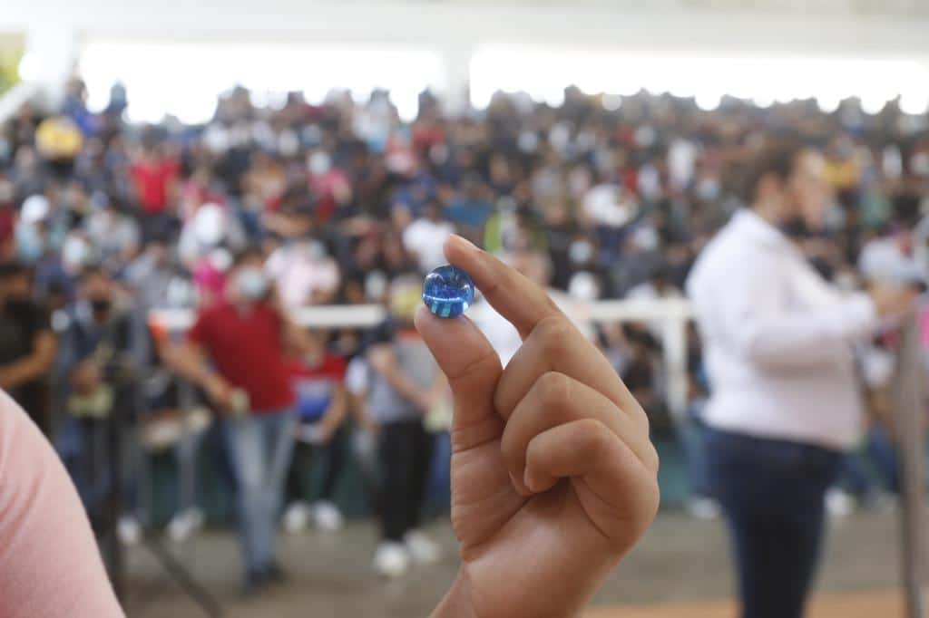 Mano con canica azul del Servicio Militar Nacional.