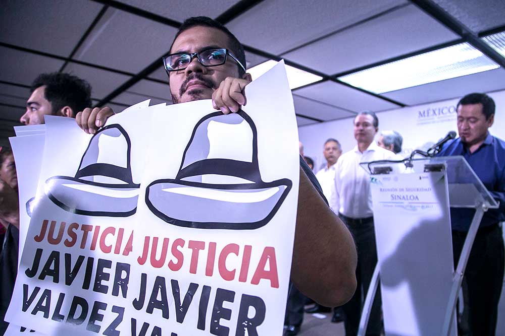 Marcos Vizcarra sosteniendo pancartas en las que se pide justicia por Javier Valdez