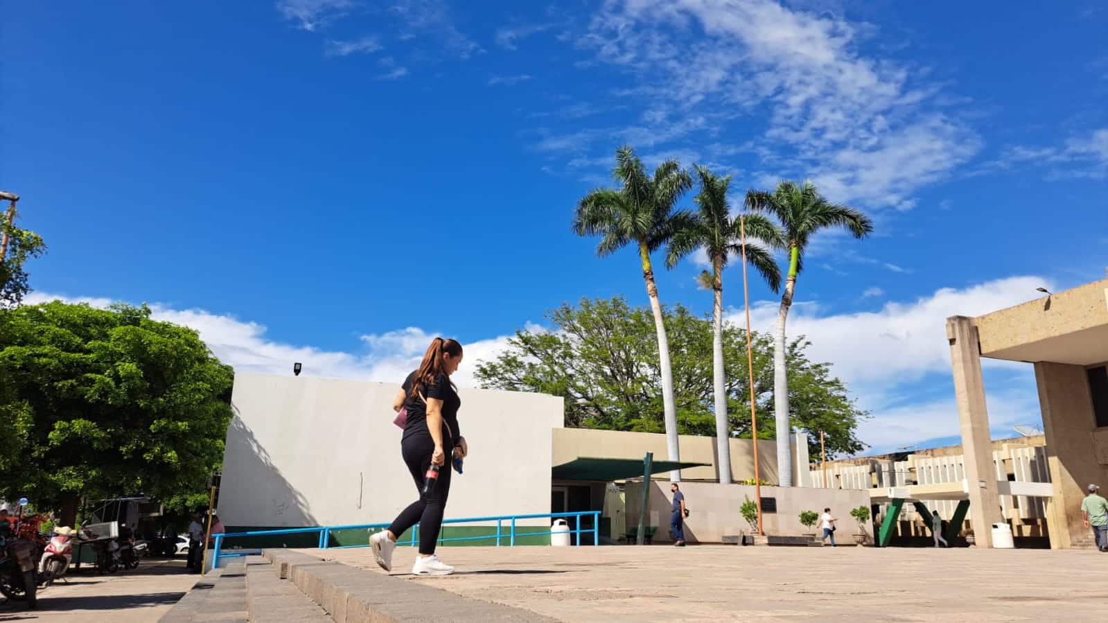 mujer caminando en Guasave, toma contra picada que muestra el cielo