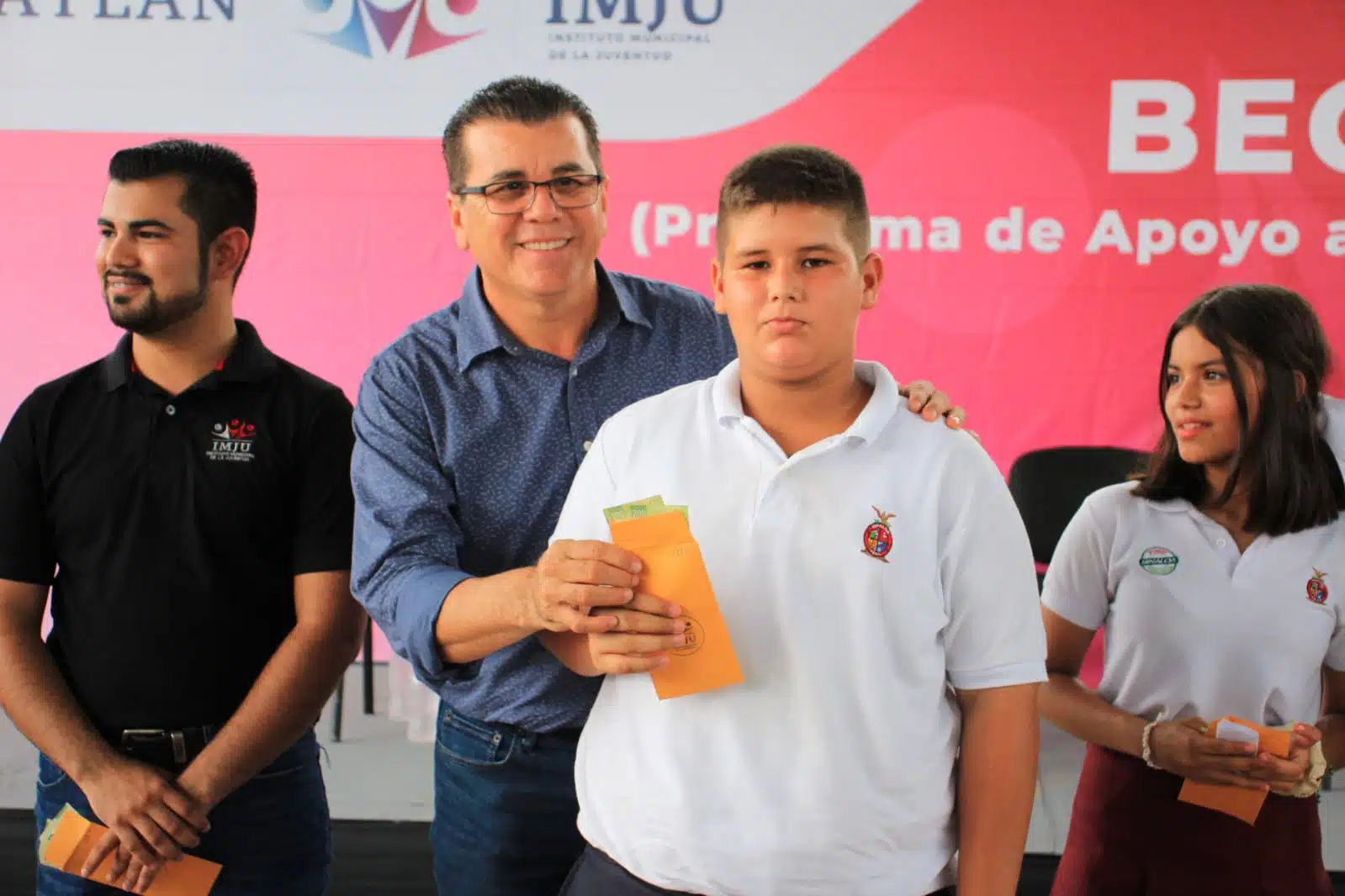 Alcalde de Mazatlán con estudiante haciendo entrega de su apoyo.