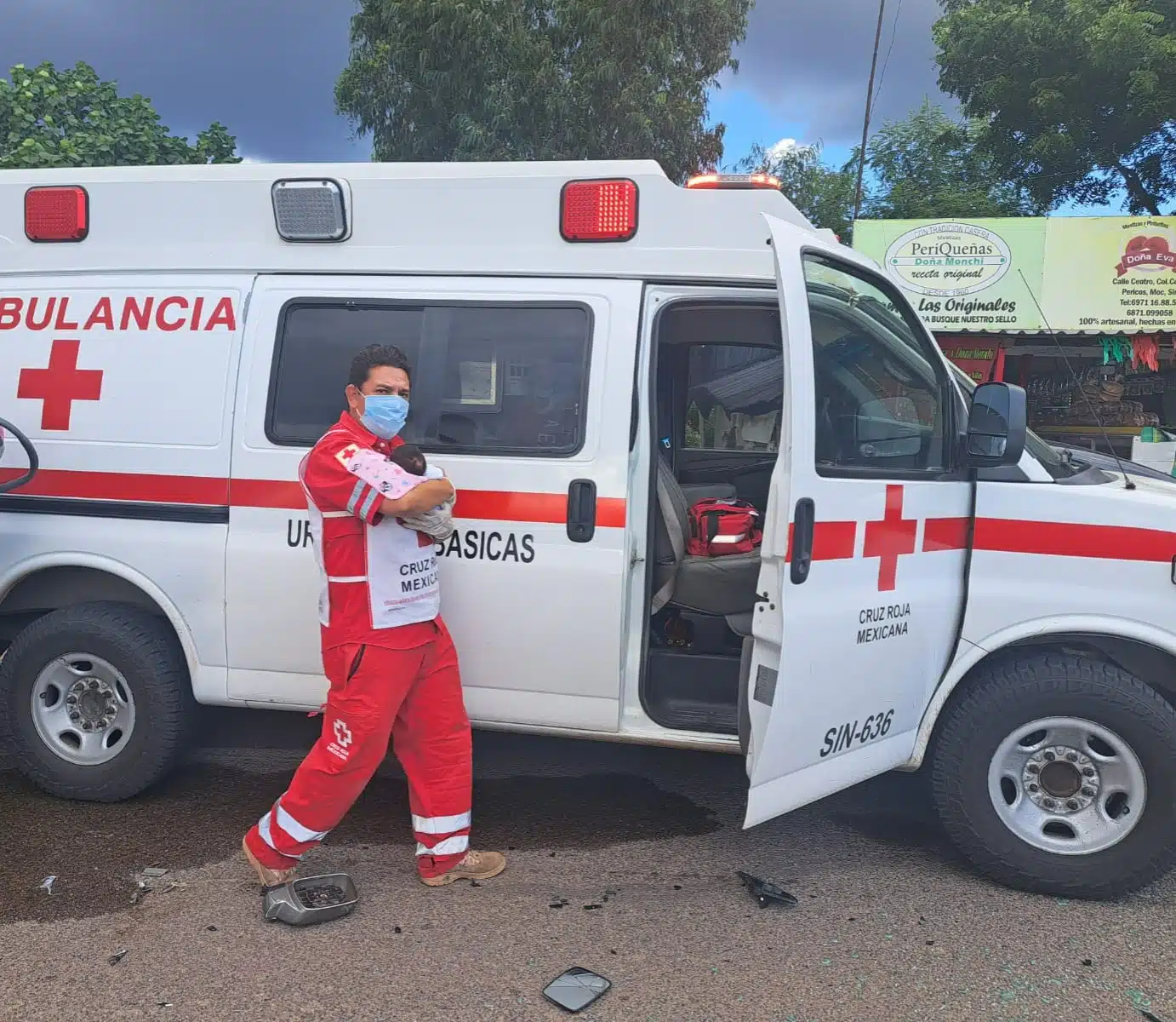 Paramédico de Cruz Roja llevando en sus brazos a la bebé lesionada por el accidente