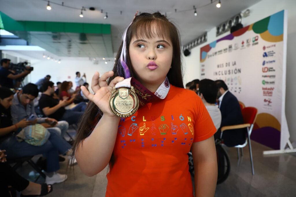 Niña con padecimiento de Síndrome de Down mostrando su medalla