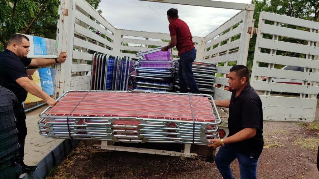 Protección civil entregando camas en refugios