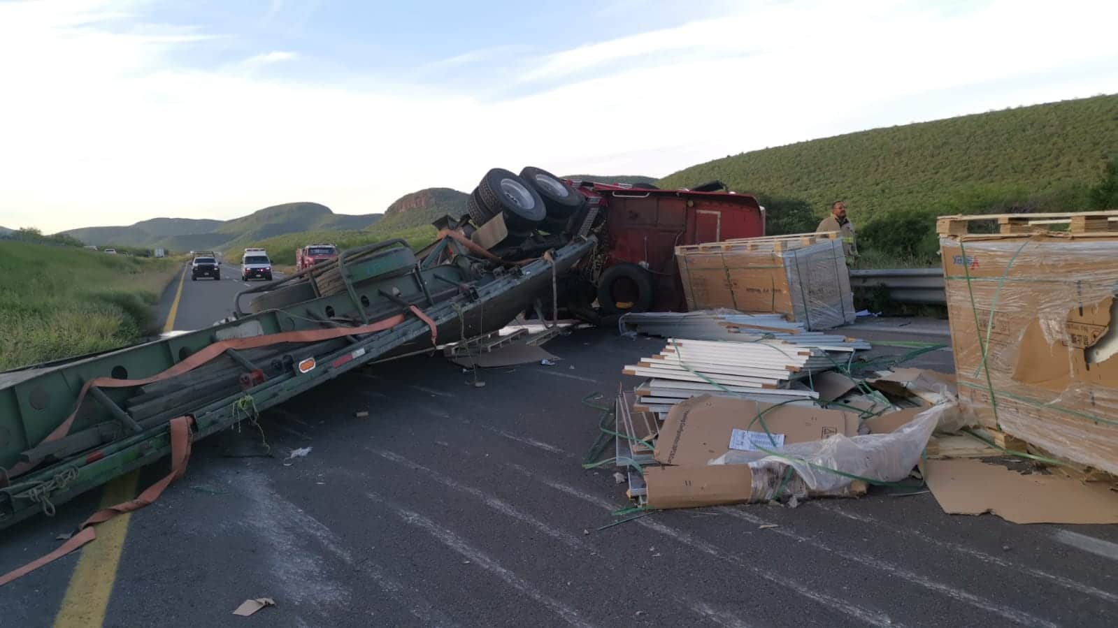 Tráiler volcado y paneles solares regados por la carretera