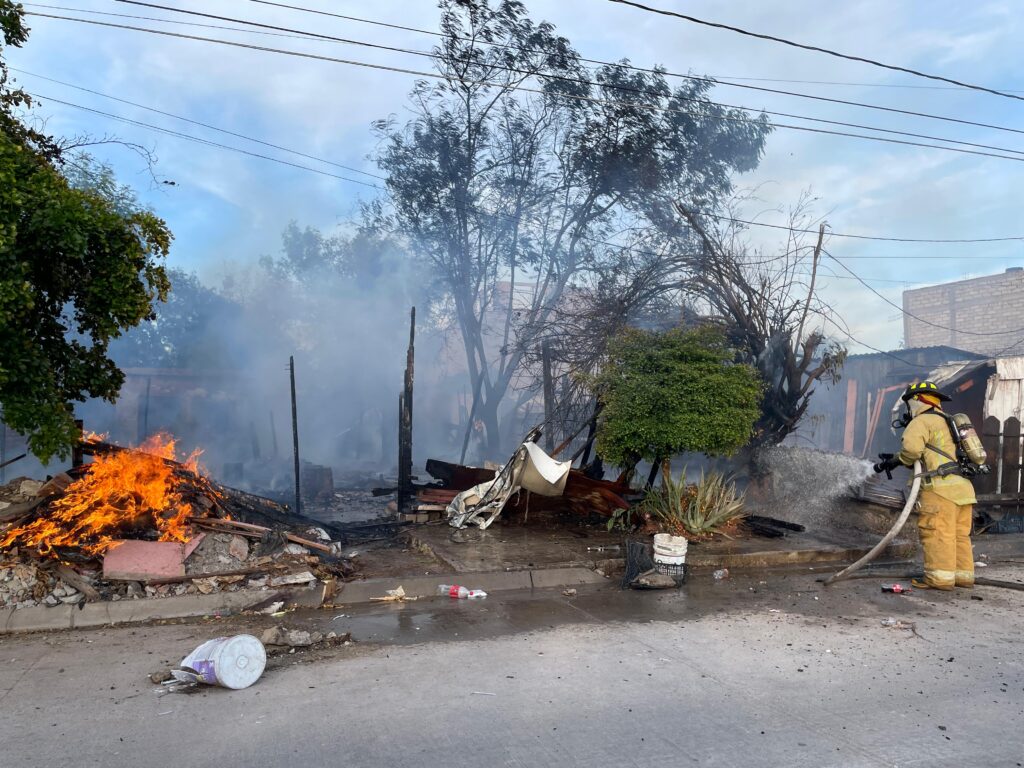 Bomberos sofocando el incendio de una casa en la colonia Libertad
