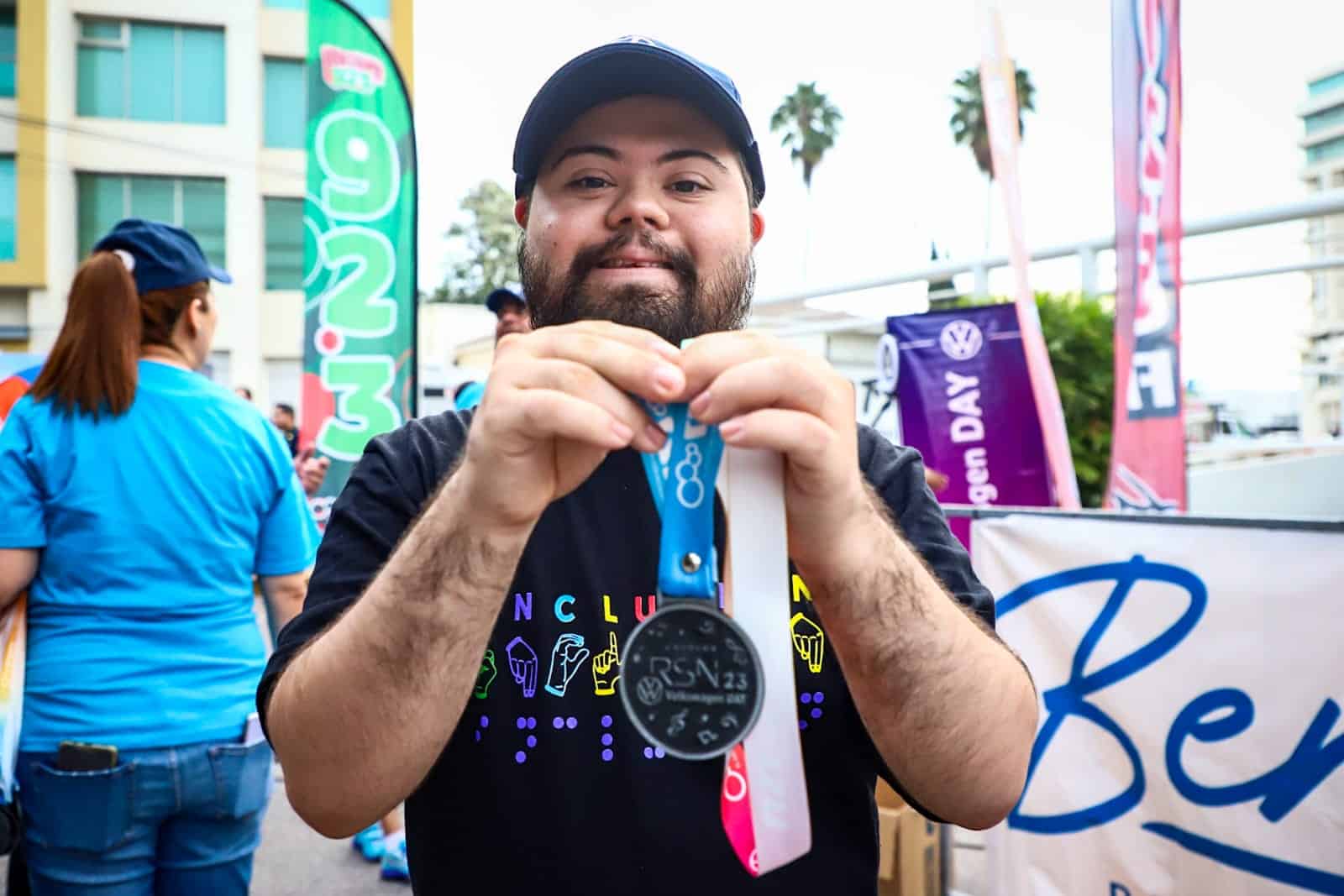 Integrante de Emplea-M con Causa sosteniendo una de las medallas otorgadas en la Carrera RSN-Volkswagen Day 2023