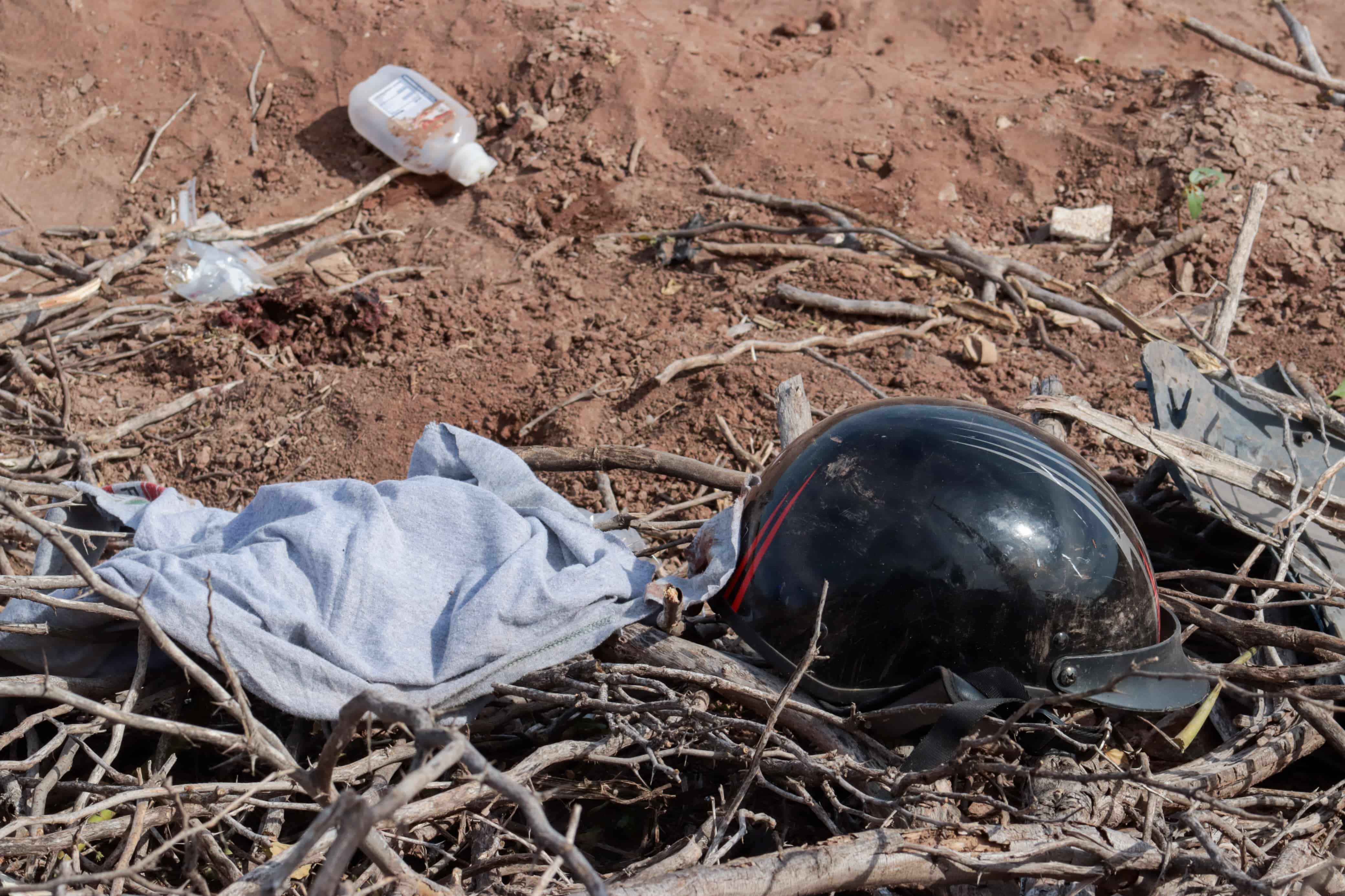 Casco de motociclista tirado entre la tierra