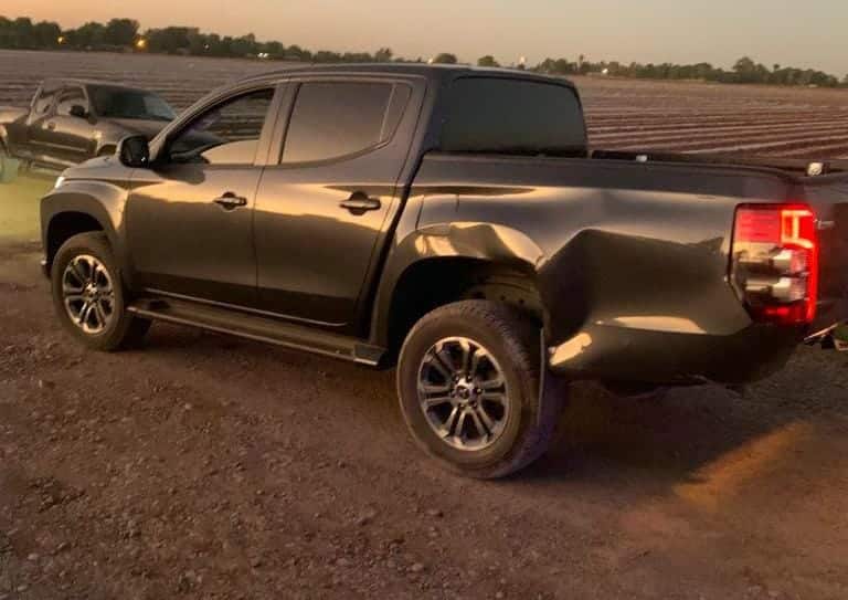 Camioneta Mitsubishi, color gris, con un golpe en la parte izquierda