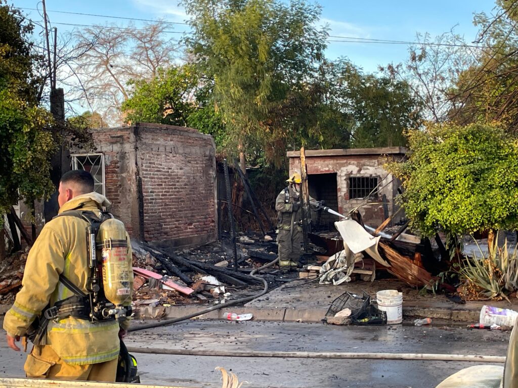 Bomberos sofocando el incendio de una casa en la colonia Libertad