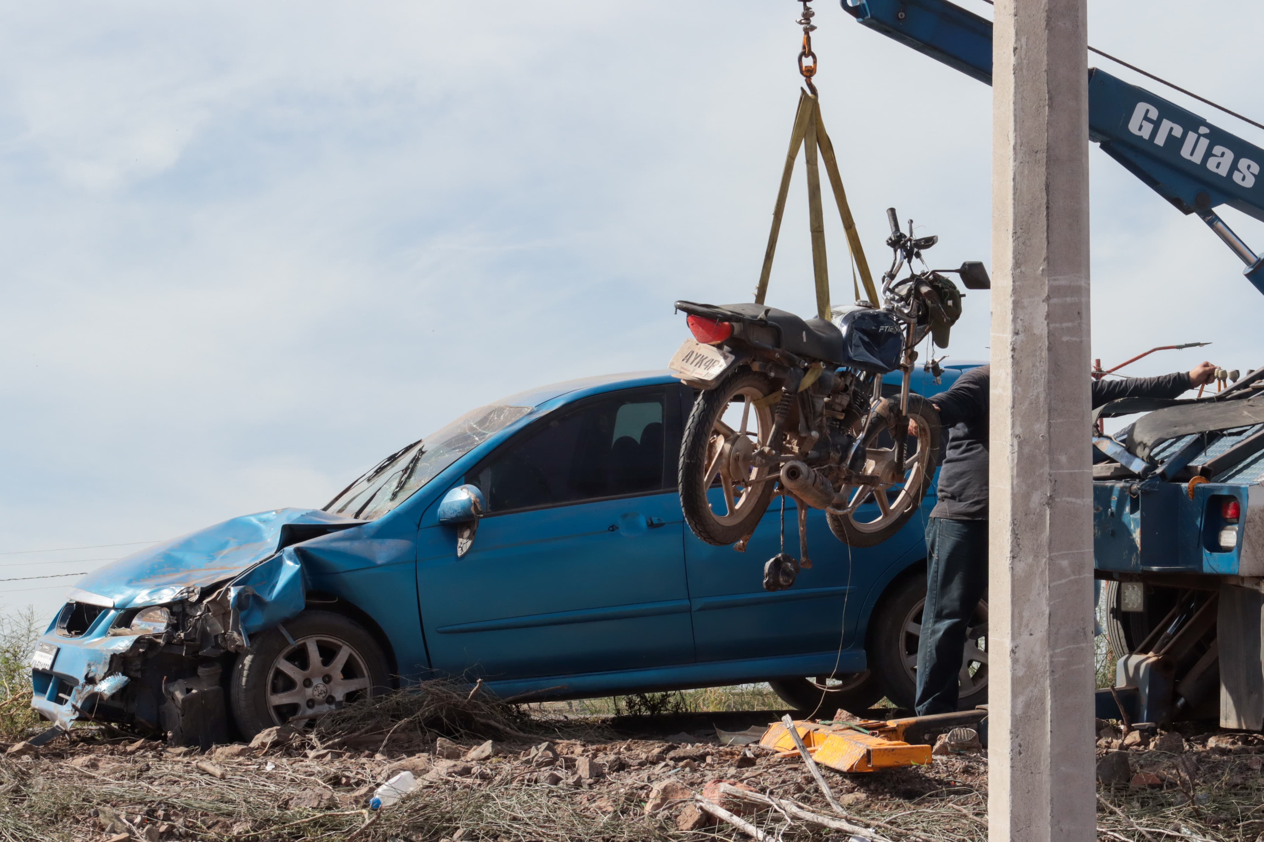 Autoridades retirando con una grúa la motocicleta involucrada en el accidente