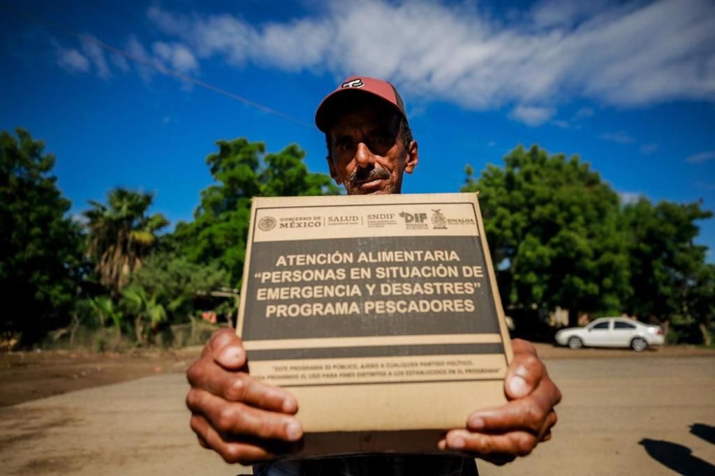 Pescador sosteniendo su despensa entregada por sistema DIF