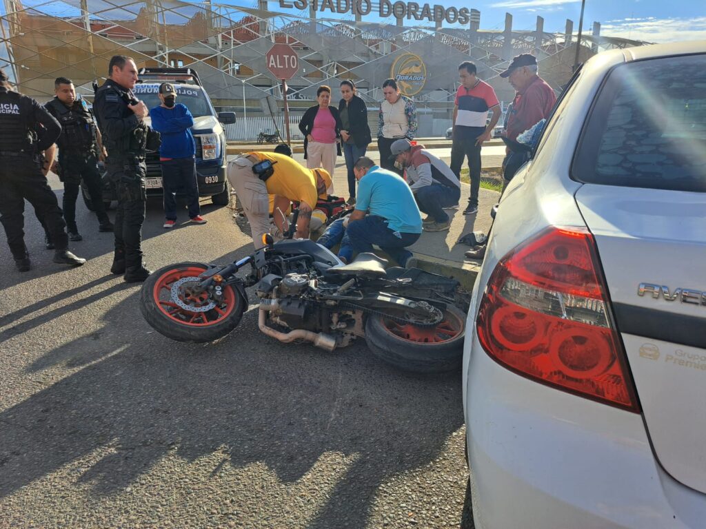 Una motocicleta en el pavimento y su conductor recibiendo atención medica en Culiacán