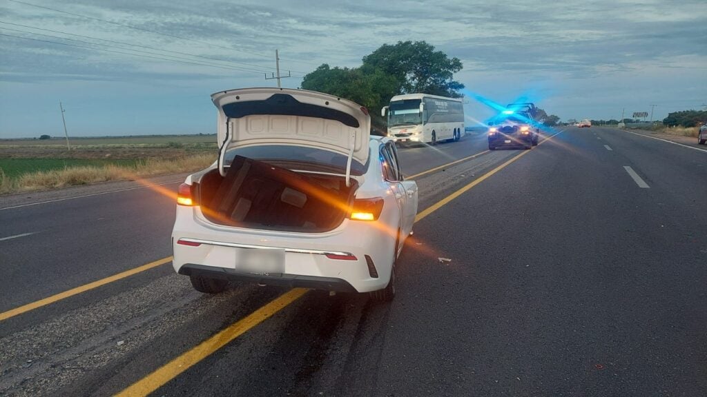 Carro con la cajuela abierta en el medio del camellón de la carretera en Angostura