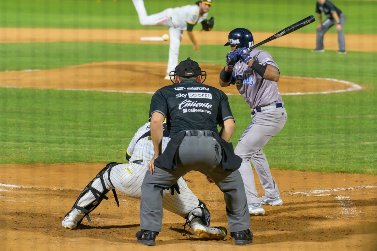 2 personas con uniforme de beisbol uno del equipo de Cañeros de Los Mochis y otro de Algodoneros de Guasave