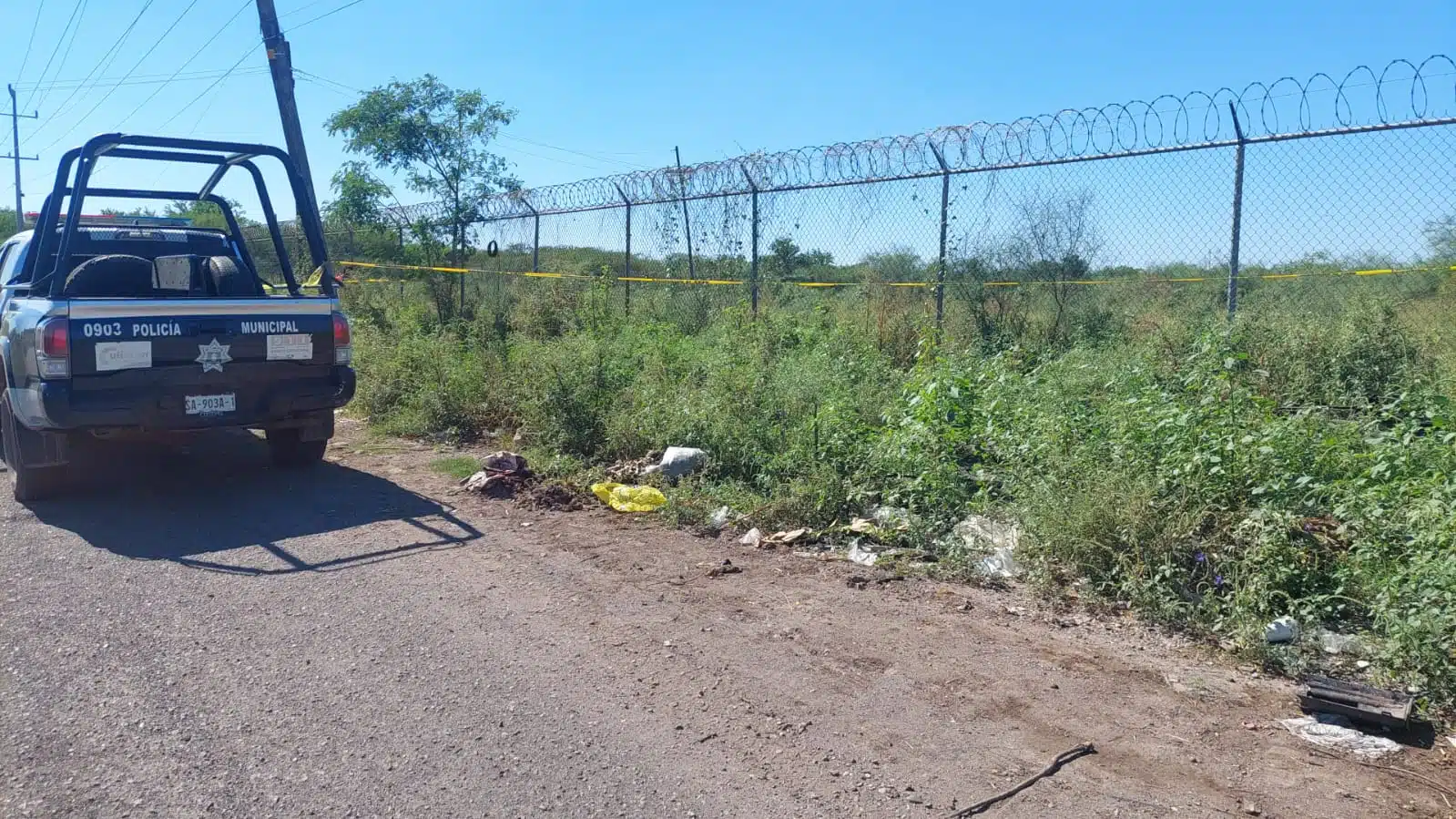 Camioneta de la policía municipal y cinta amarilla delimitando el lugar del hallazgo.