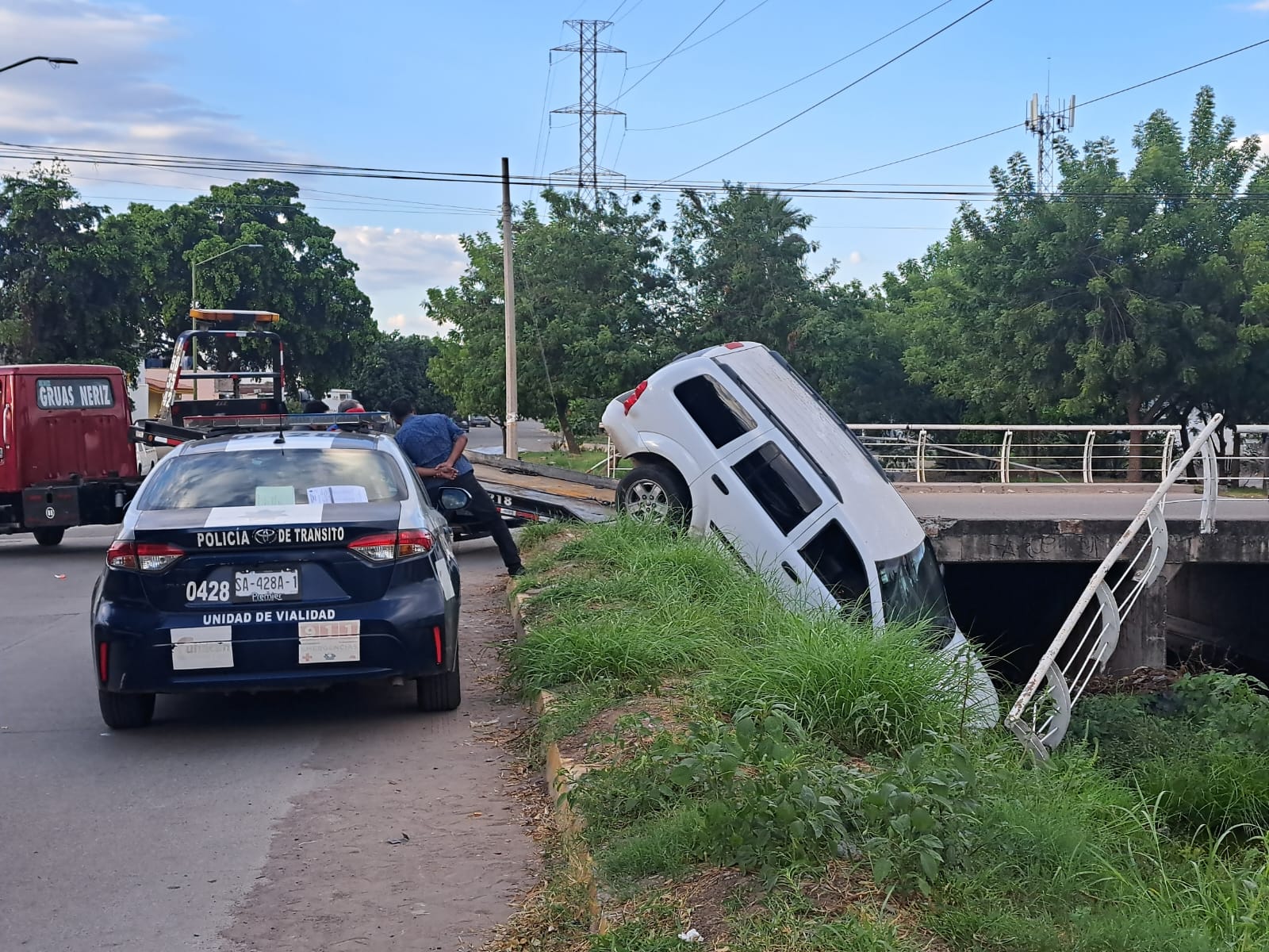 camioneta Suburban blanca cae a canal.