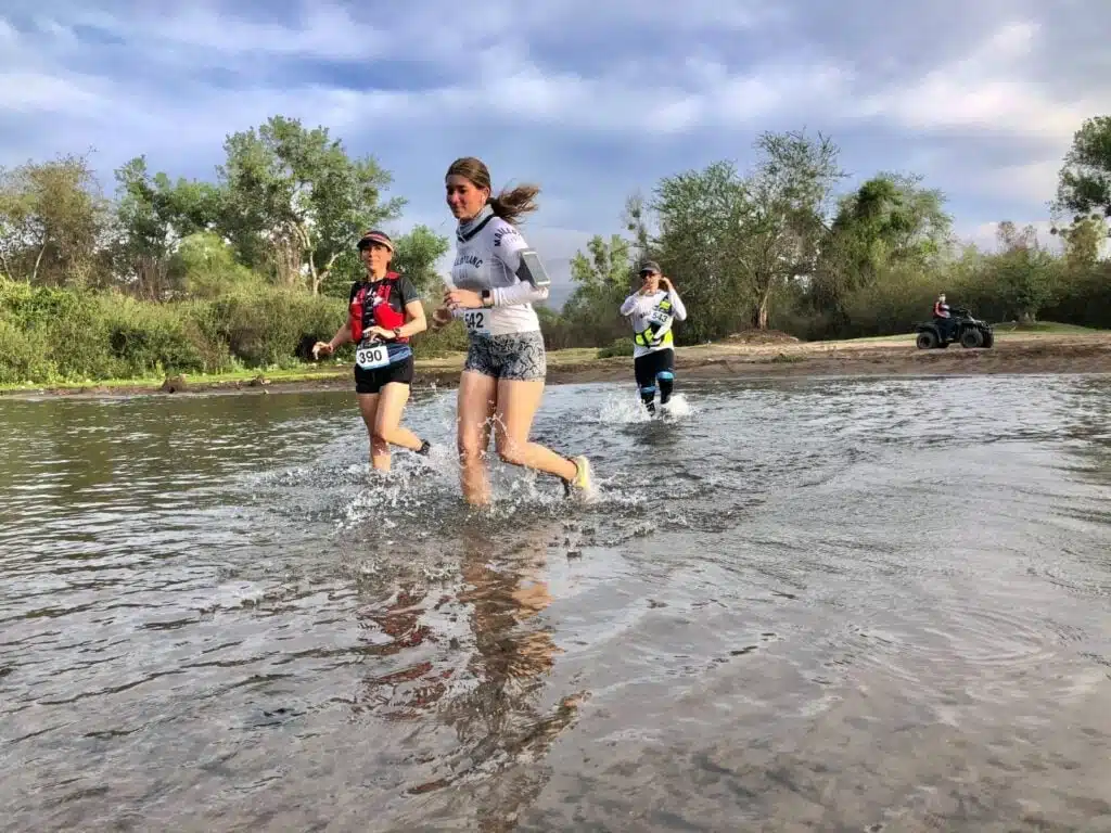 2 personas corriendo en las aguas de un río