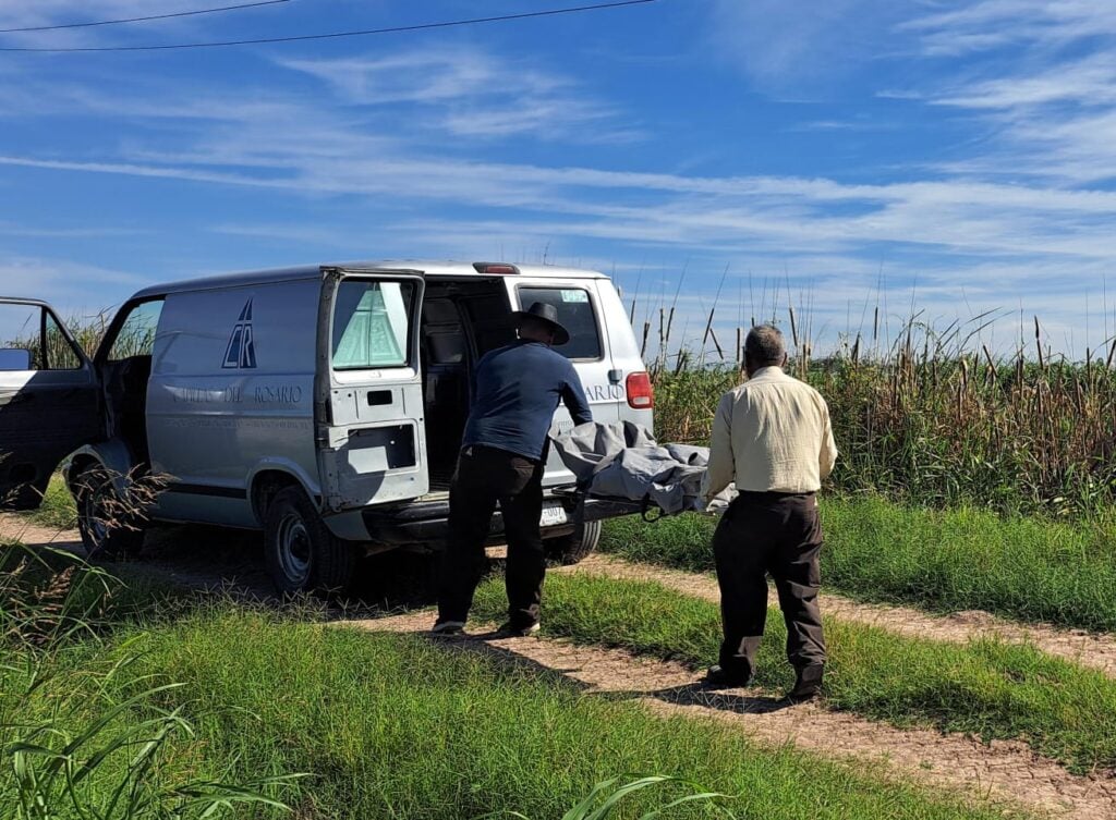 Personal de una funeraria en el lugar donde encontraron un cuerpo calcinado en Guasave