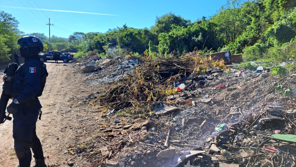 Agente de la PEP junto a un predio usado como basurero donde encontraron a un hombre asesinado y carbonizado 