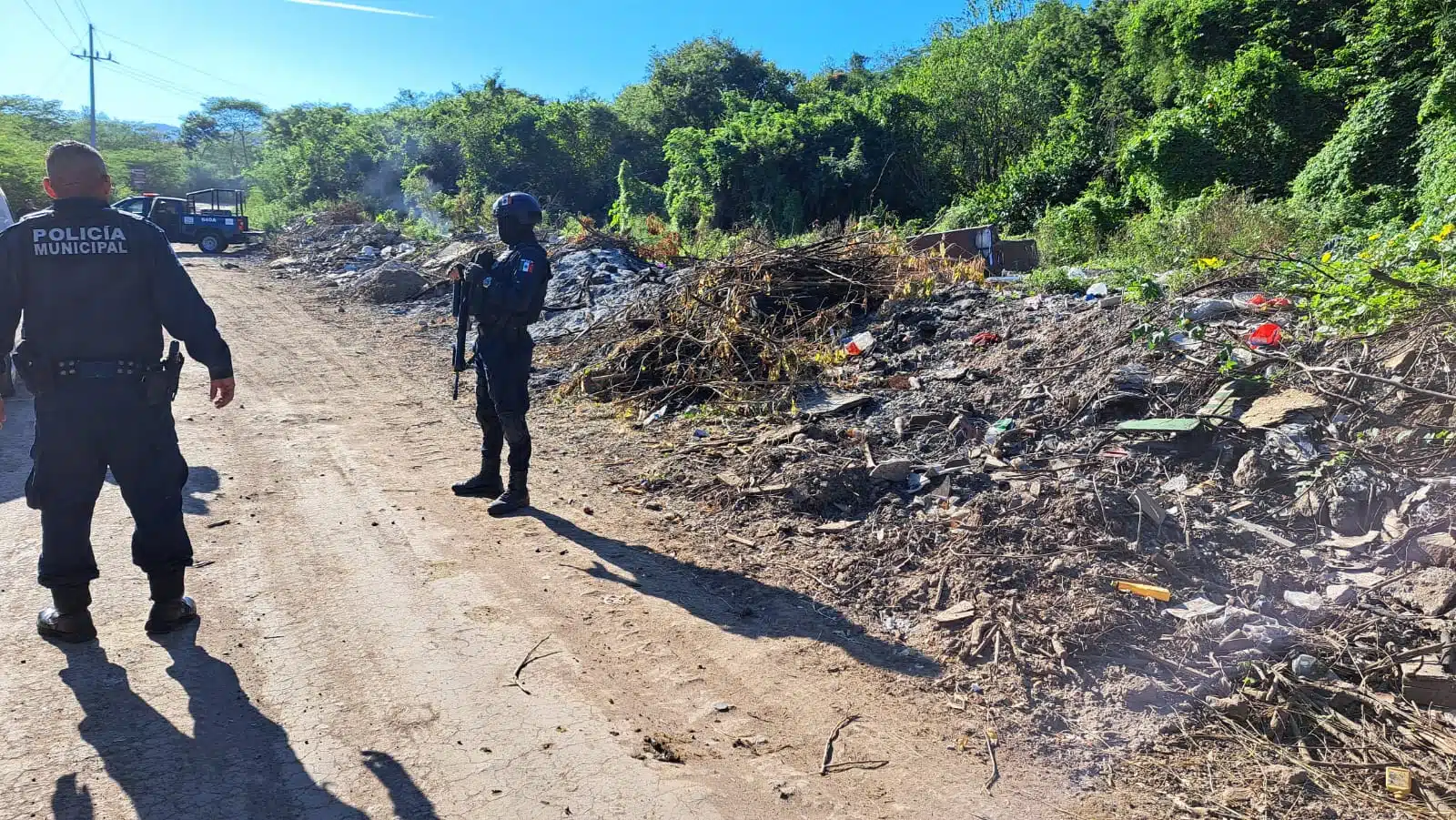 Agente de la PEP junto a un predio usado como basurero donde encontraron a un hombre asesinado y carbonizado