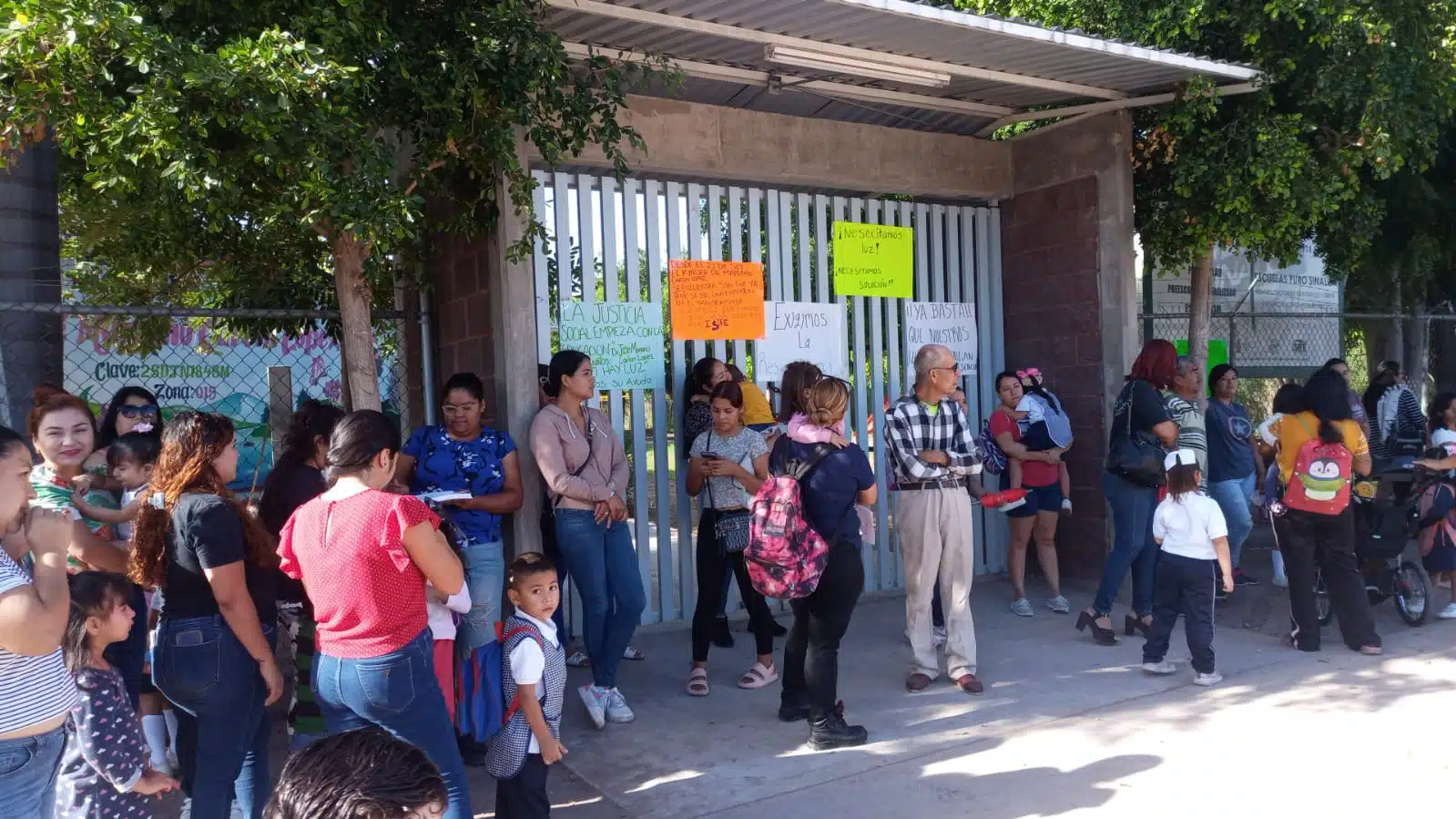 Madres de familia afuera de las instalaciones del plantel educativo.