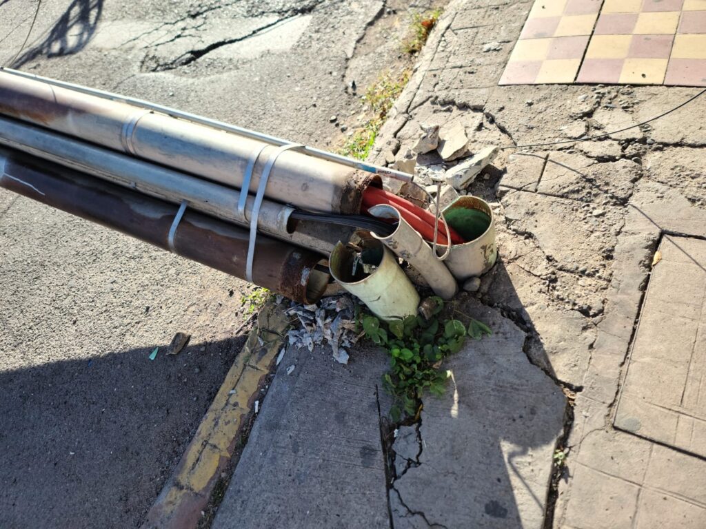 Poste y cableado sobre el pavimento obstruyendo el paso en Culiacán
