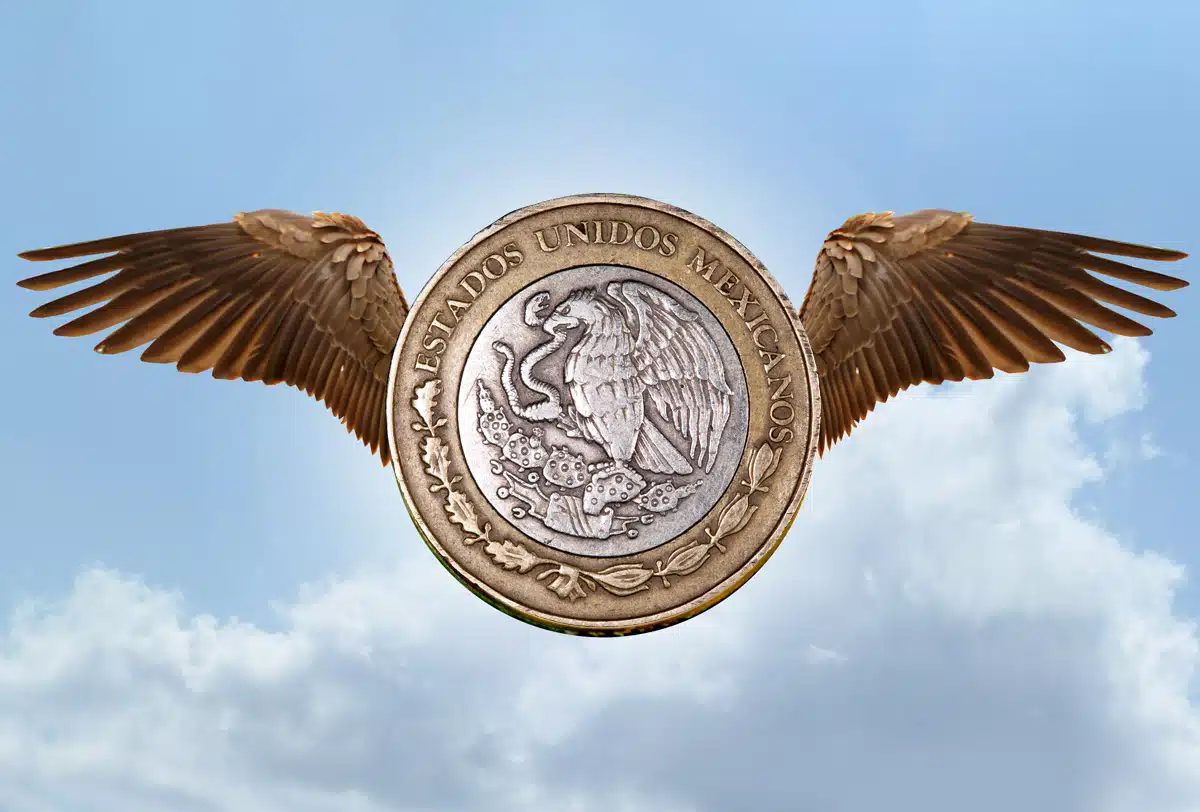 Moneda de México con alas por las nubes