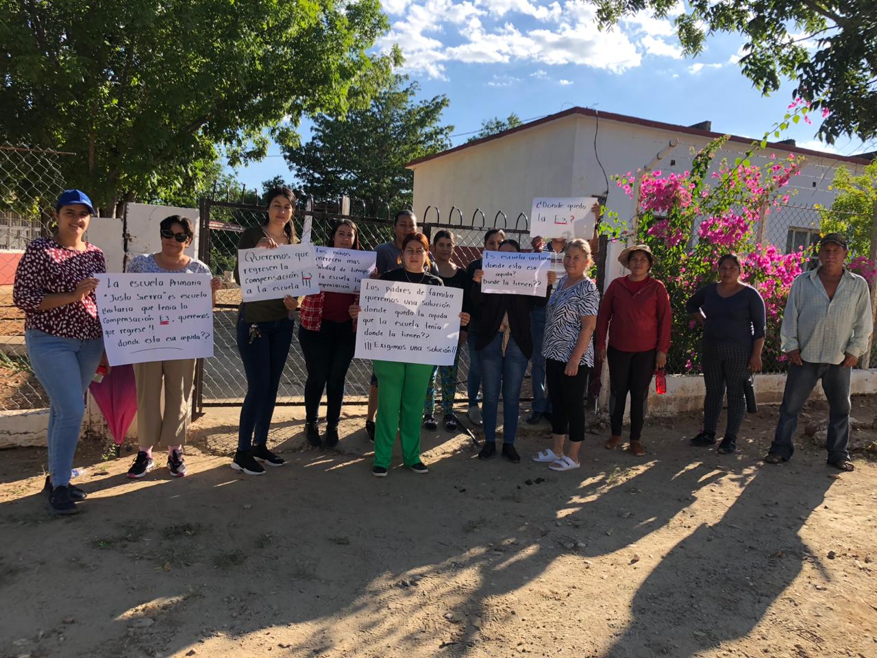 Padres de familia con pancartas con leyendas de protesta en escuela que tomaron en El Realito, El Fuerte