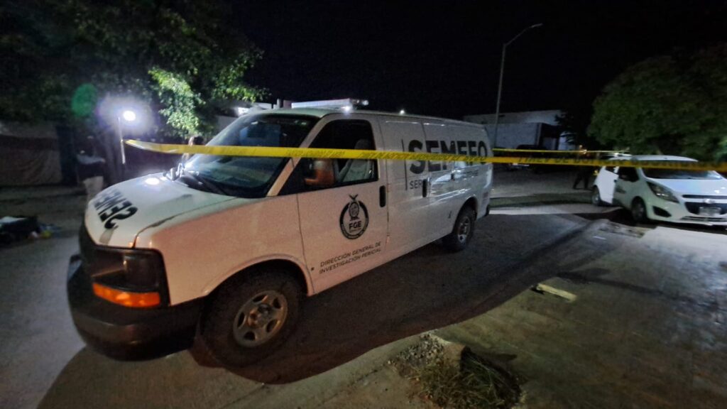 Camioneta de SEMEFO y cinta amarilla delimitando el área de un crimen en el lugar donde asesinaron a un hombre en Culiacán