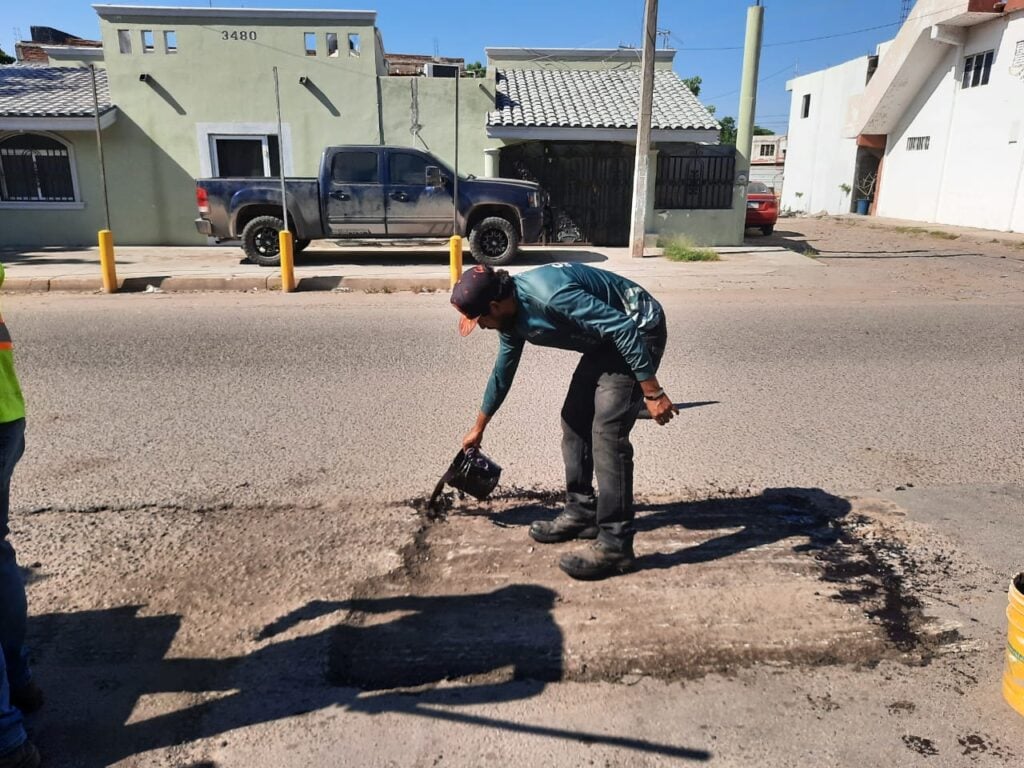 trabajador tapando bache