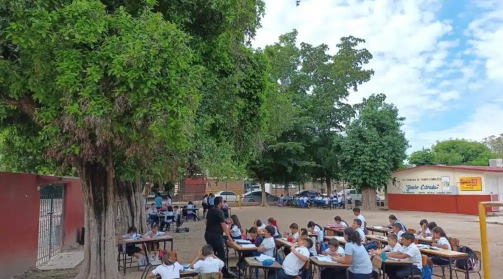 Niños tomando clases fuera del aula
