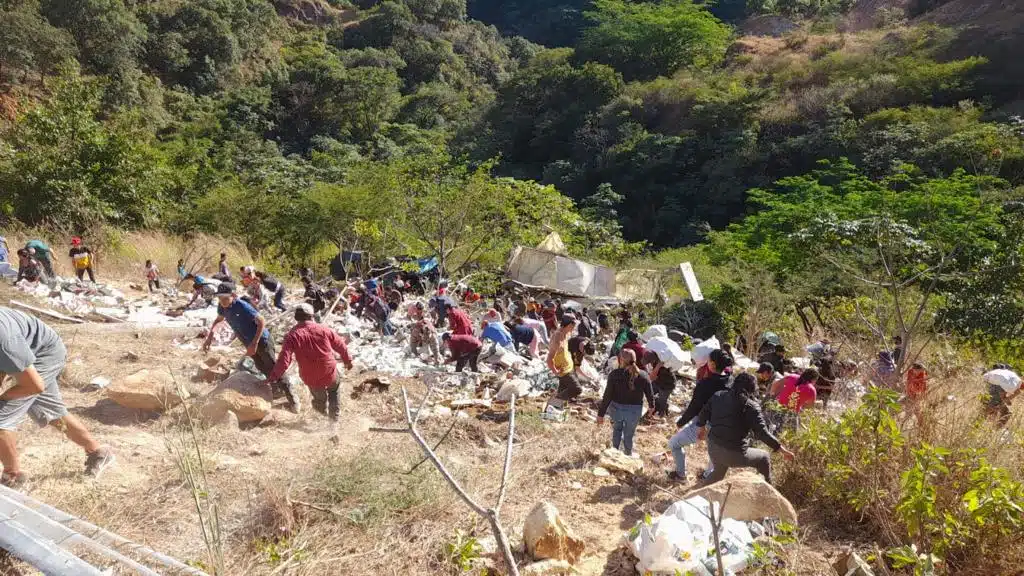 Personas realizando rapiña tras el accidente de la pesada unidad de carga