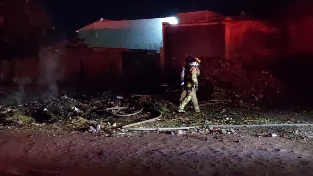 Bomberos sofocando el fuego en unas ramas secas