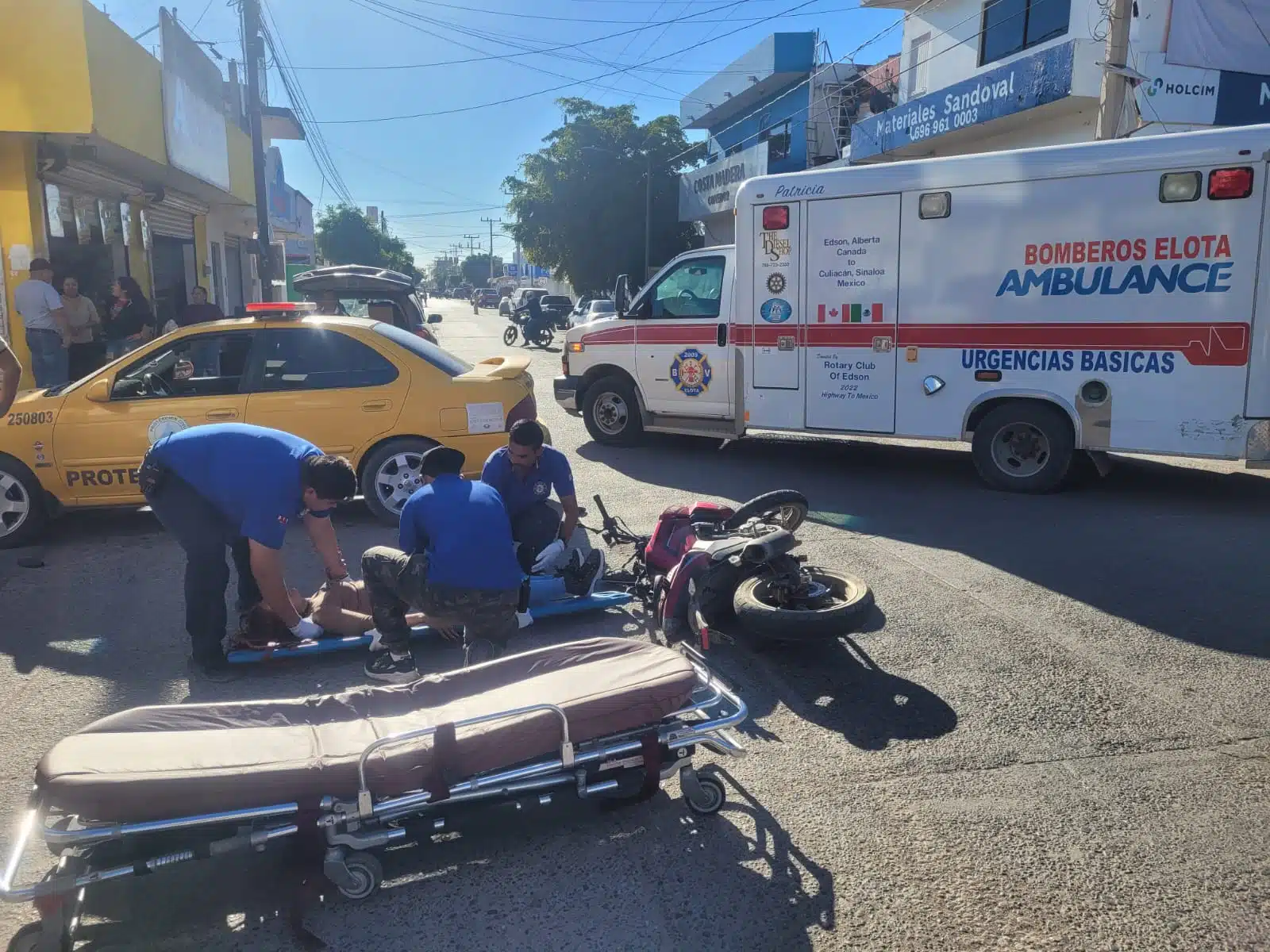 Paramédicos de Bomberos auxiliando a una motociclista lesionada