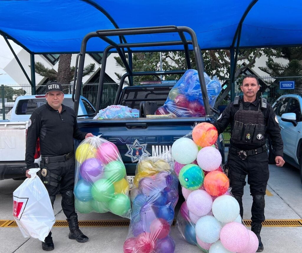 2 personas con uniforme de policía, una patrulla y pelotas en Ahome