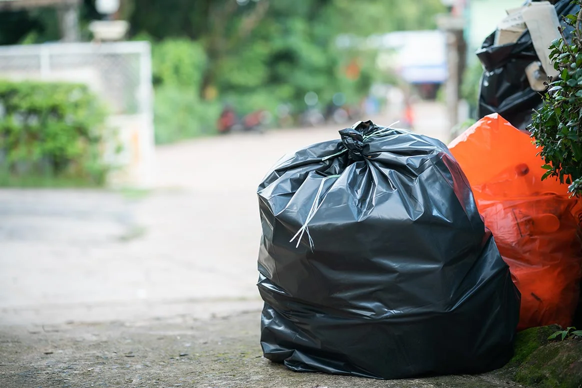 Bolsas de basura afuera de una vivienda