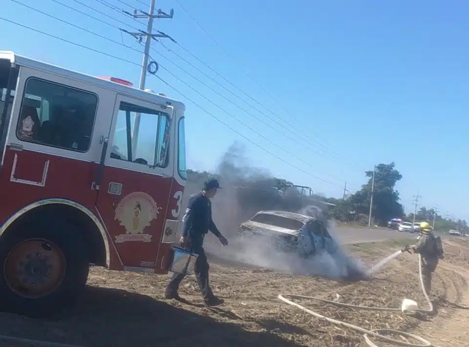 Bomberos apagando un incendio de un carro en Ahome