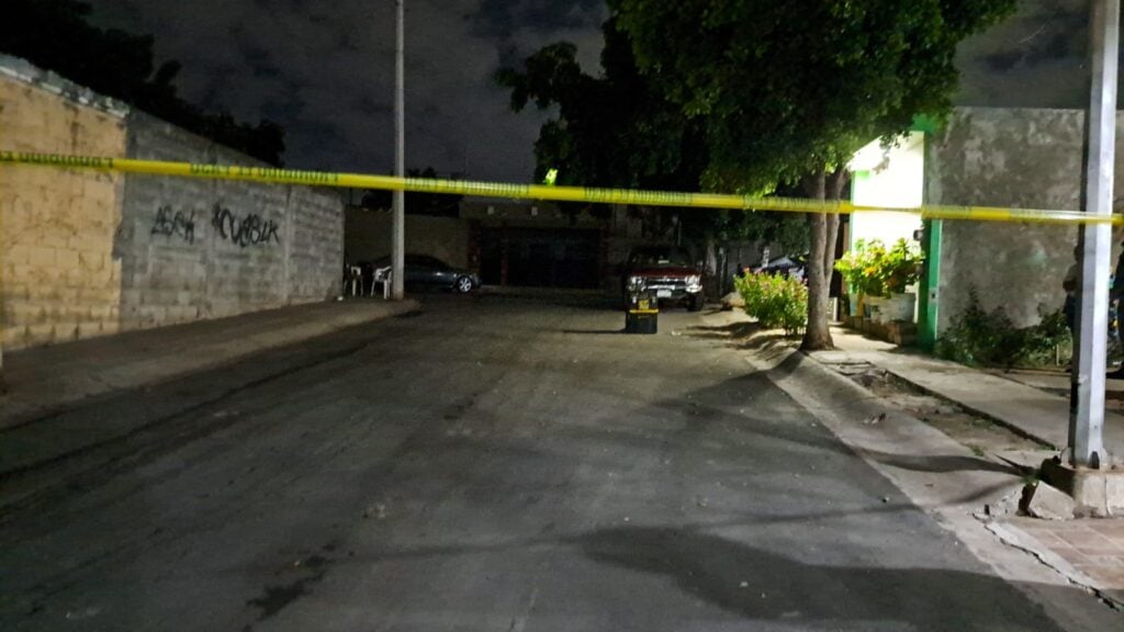 Camioneta de la policía Municipal y cinta amarilla delimitando el área en donde encontraron a una persona asesinada en Culiacán