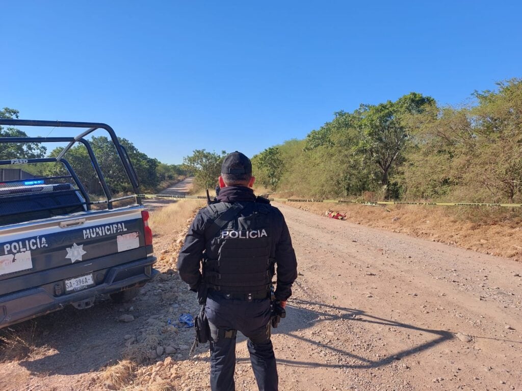 Policía Municipal junto a una patrulla en un camino de terracería donde hallaron el cuerpo sin vida de un hombre