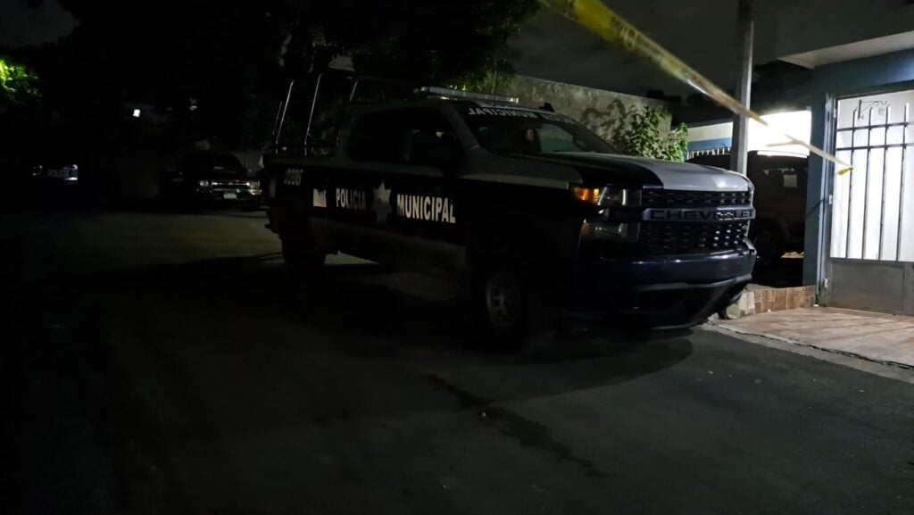 Camioneta de la policía Municipal y cinta amarilla delimitando el área en donde encontraron a una persona asesinada en Culiacán