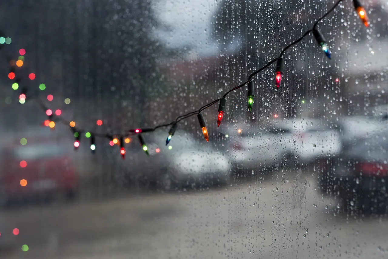 gotas de lluvias en ventana y luces navideñas