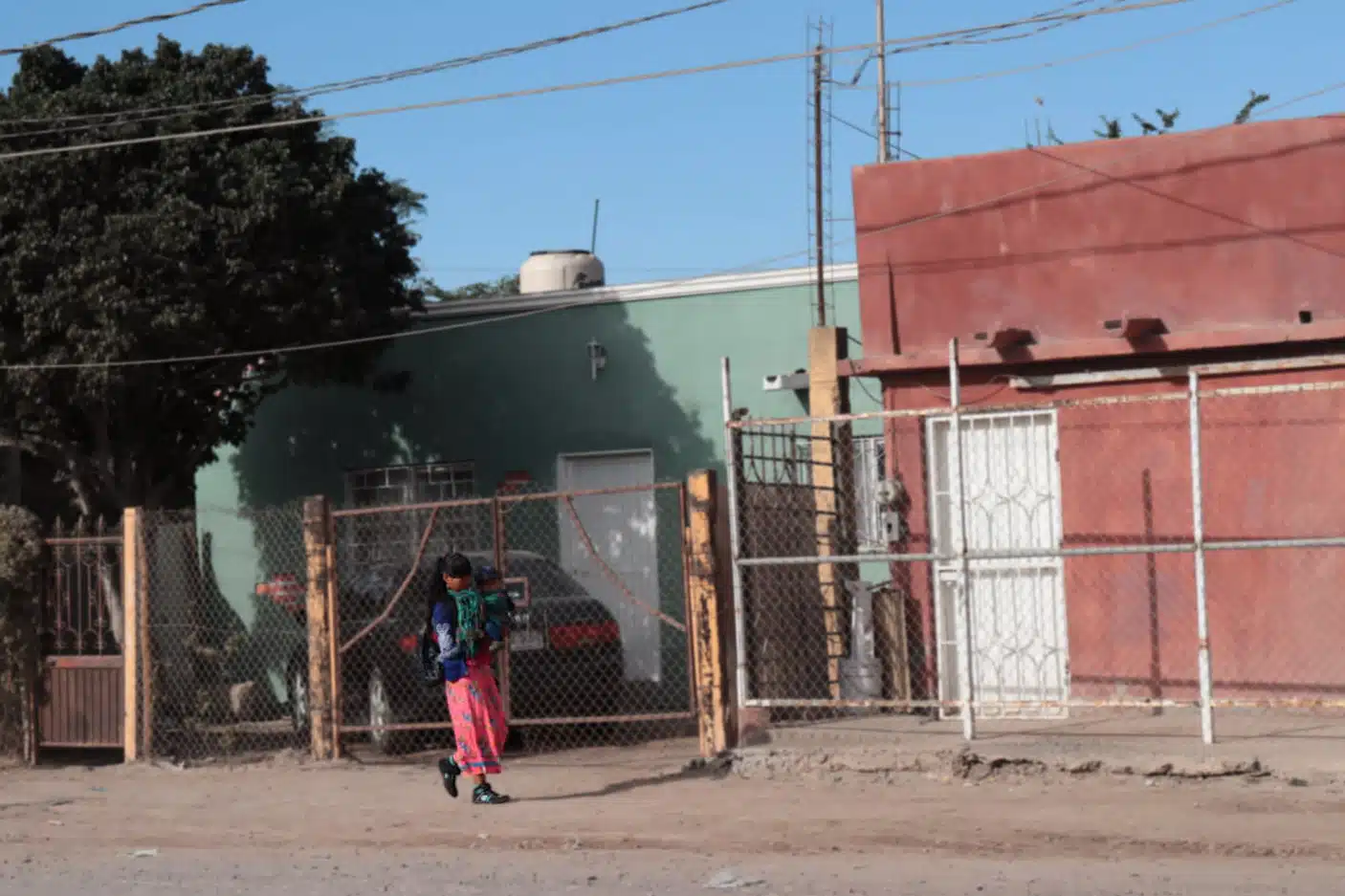 Niña de origen indígena cargando un bebé en calles de Juan José Ríos.