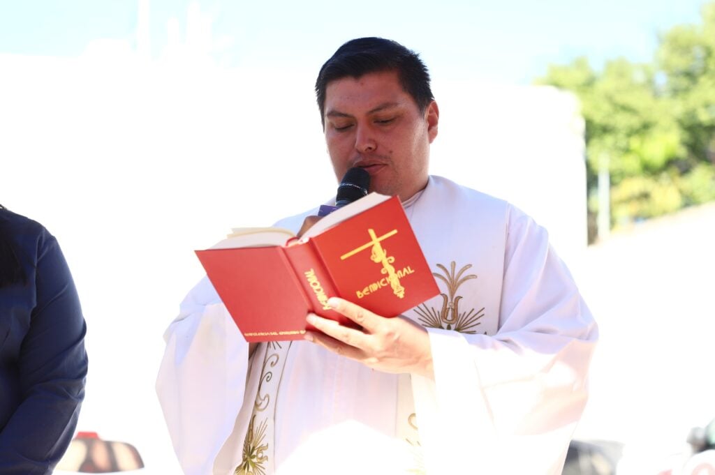 Padre celebrando misa por apertura de tienda