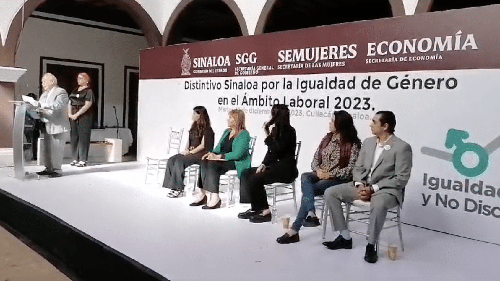 Personas sentadas y una parada en Culiacán