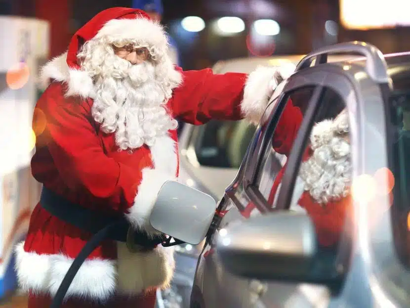 San Claus pone gasolina en un carro