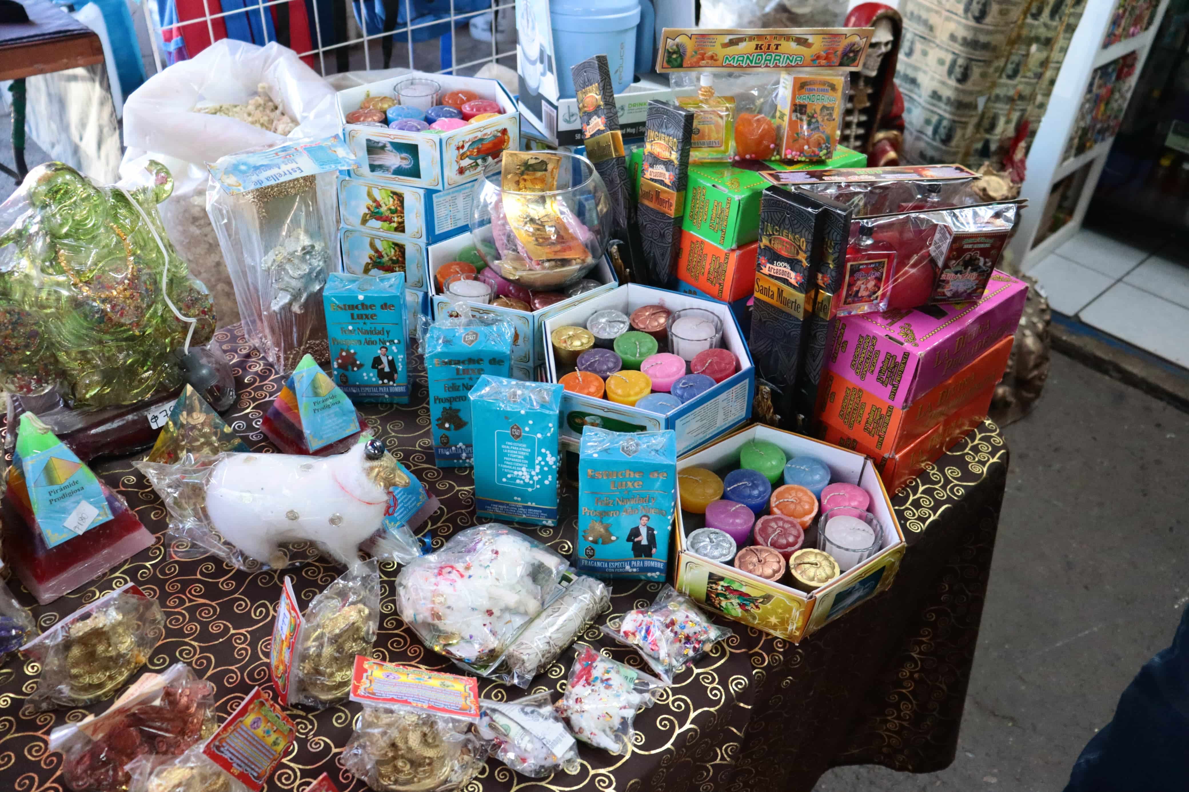 Paquetes de 12 velas, amuletos y otros artículos que pueden ser encontrados en el mercado.